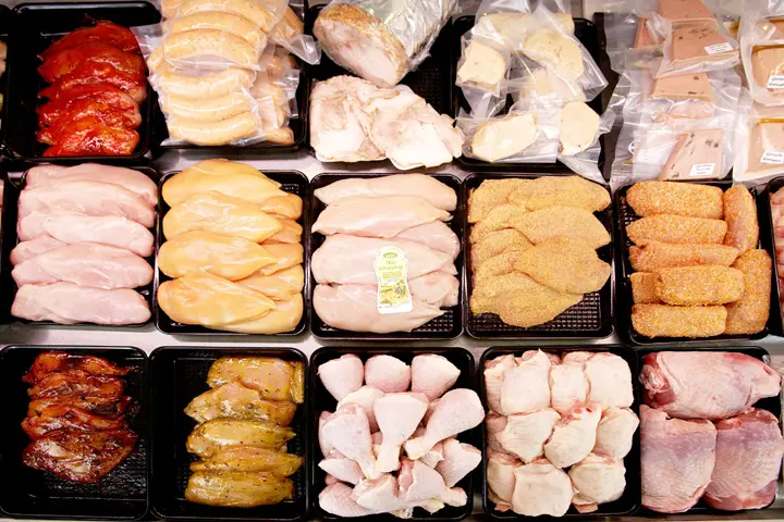 Vitrine met gemarineerde kipfilet, drumsticks en kippenbouten